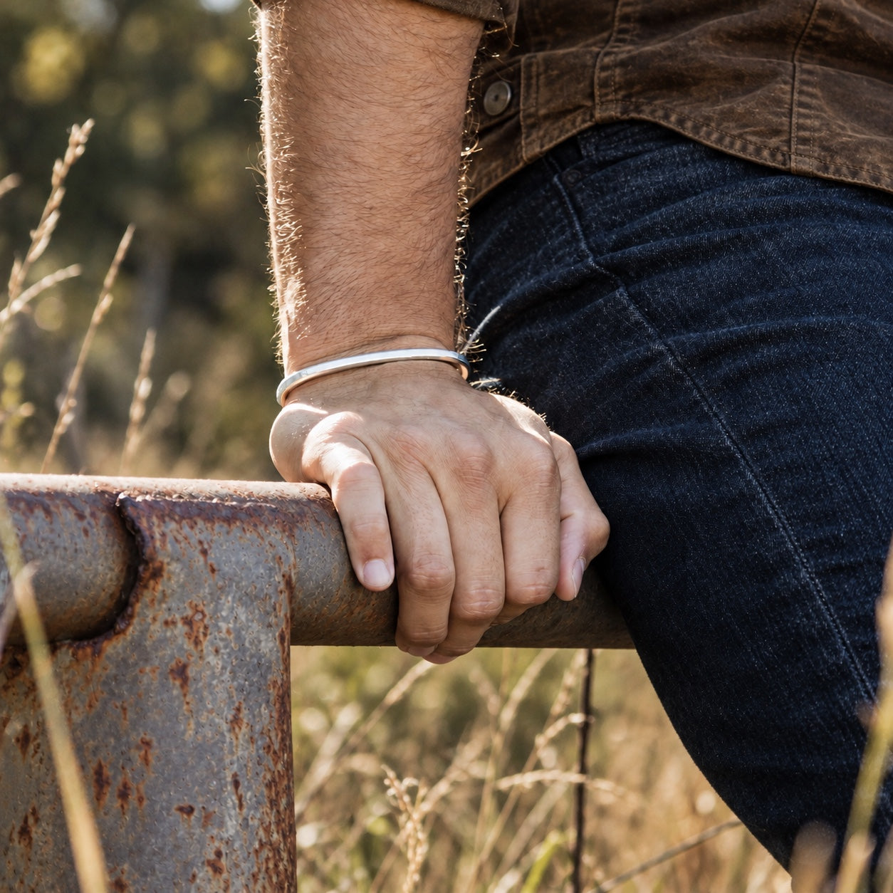 SkyBolt fine silver cuff worn at a working ranch gate